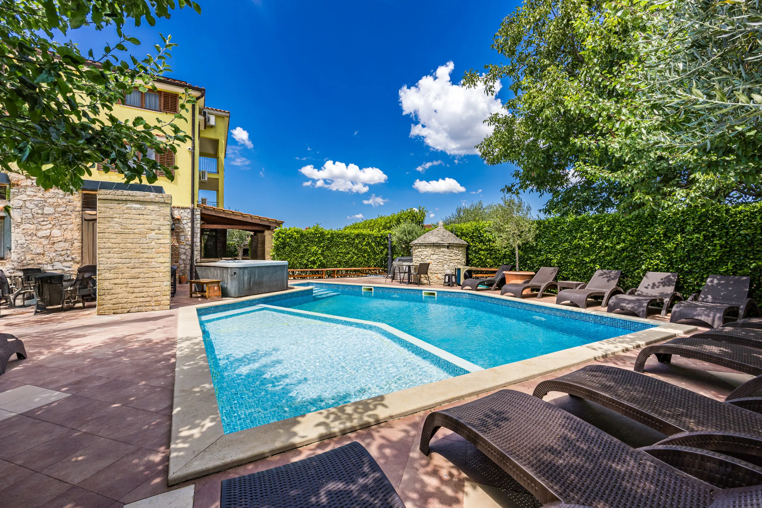 The heated pool and sun loungers in the walled garden, with the house behind