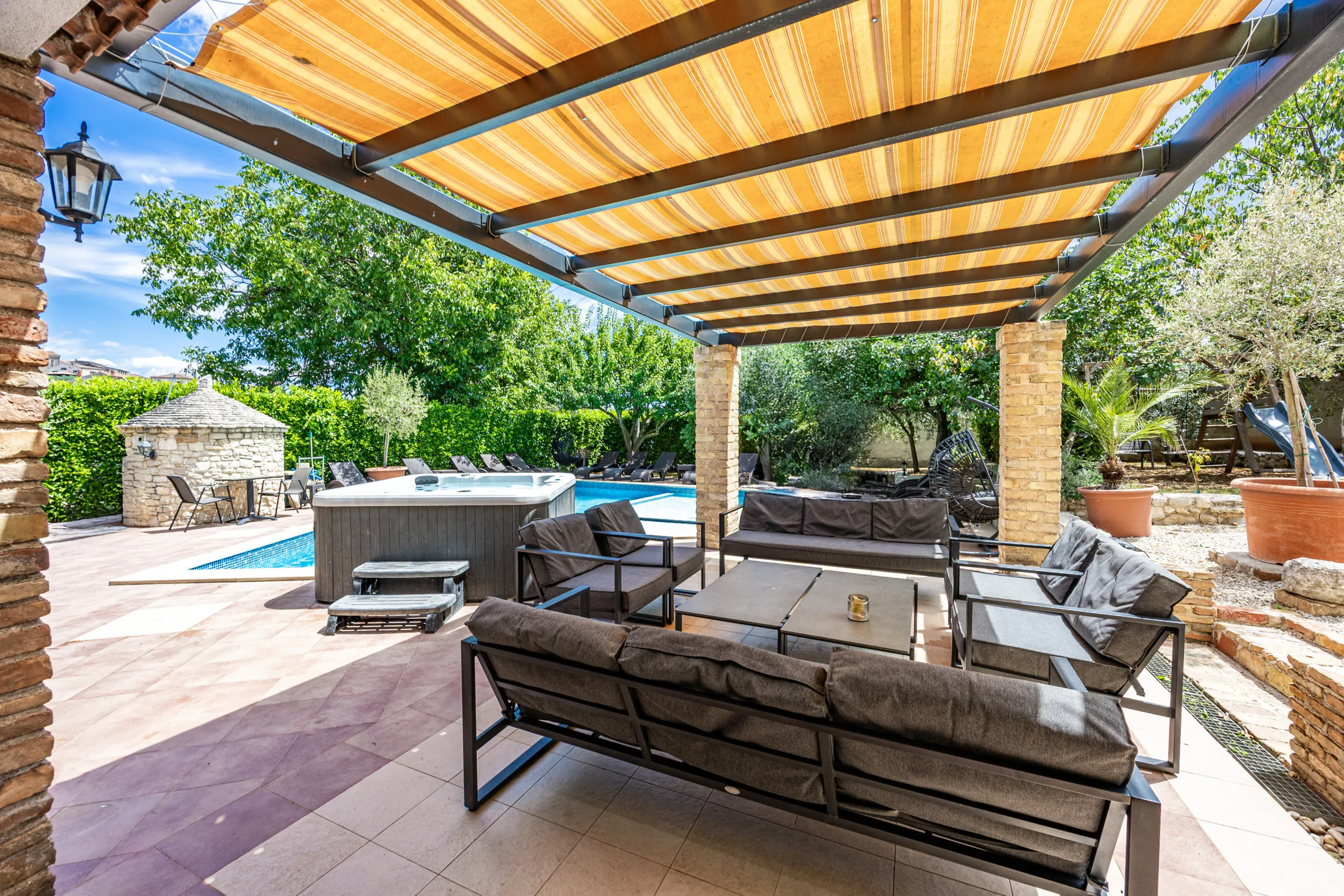 Gepolsterte Sofas und Sessel unter der Pergola