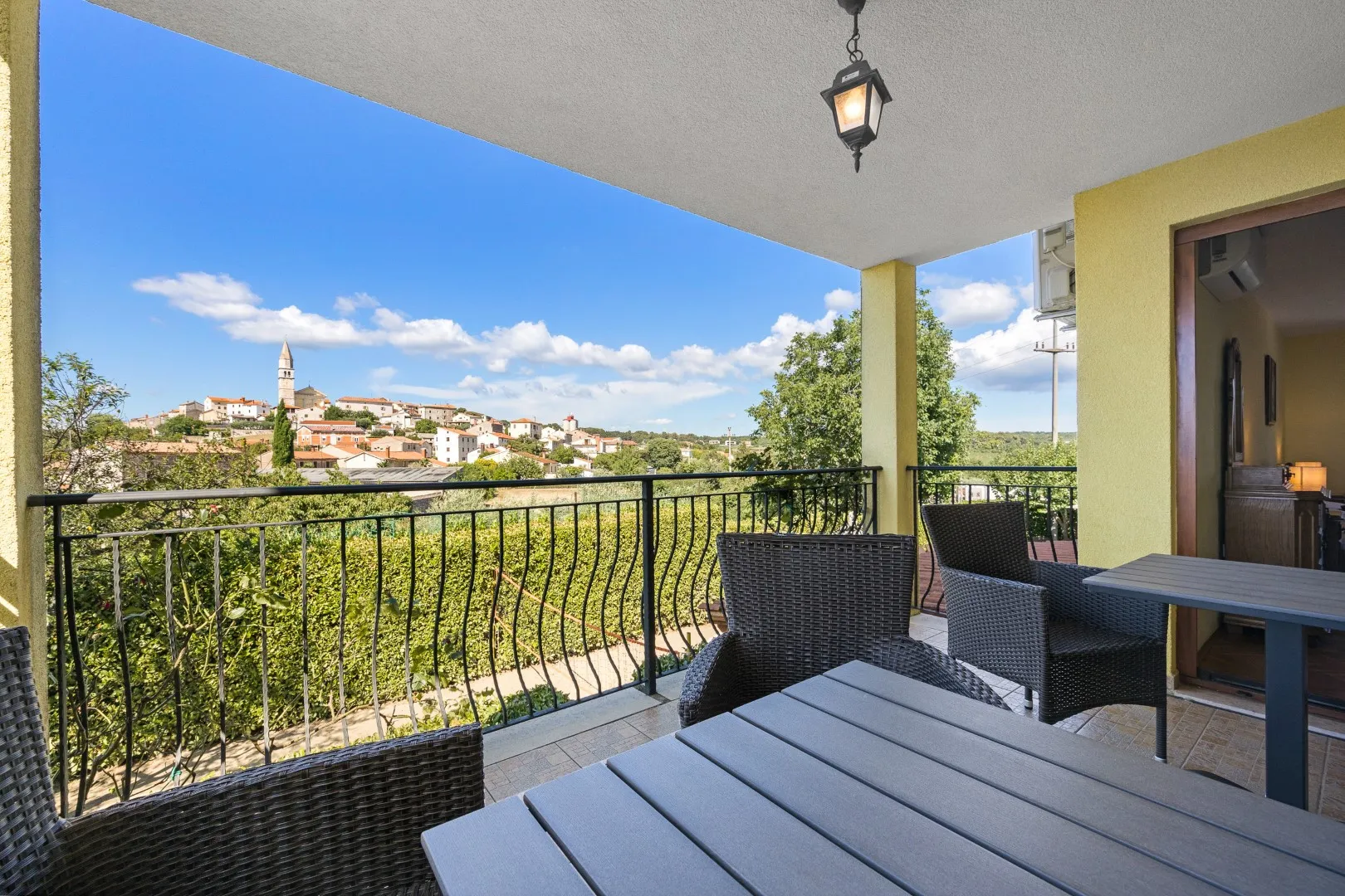 Der Balkontisch mit Blick über die Hecke zum Glockenturm des Dorfes