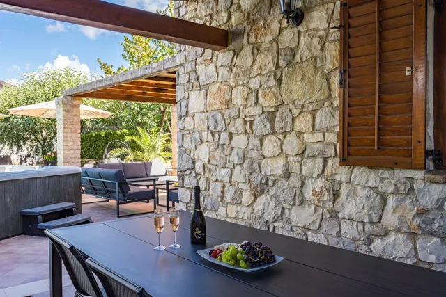 Der lange Esstisch auf der überdachten Terrasse, für eine Gruppe gedeckt
