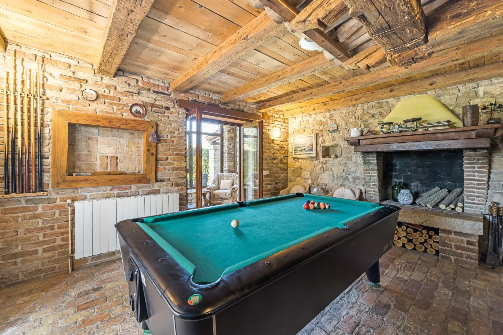 The billiards room with its pool table under a wood-beam ceiling